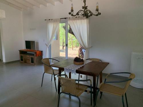 ein Esszimmer mit einem Tisch, Stühlen und einem Kronleuchter in der Unterkunft Casa Aguaribay para 4 personas, cerca del centro, Merlo San Luis in Merlo