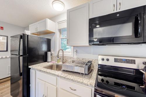 a kitchen with a stainless steel refrigerator and a sink at Misty Harbor Beach Retreat in Gilford
