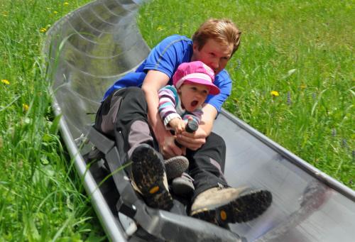 a man and a child riding in a box at JUFA Hotel Spital am Pyhrn in Spital am Pyhrn
