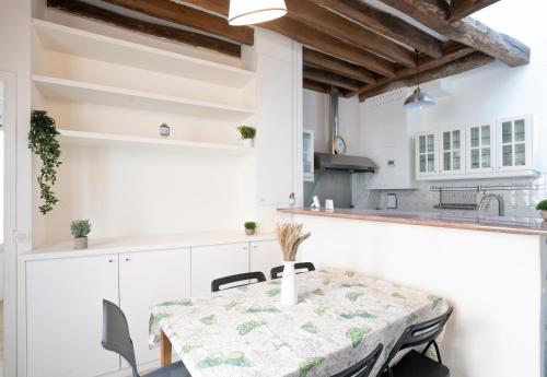 cocina blanca con mesa y sillas en Le Cocon d'Alesia ~ T3 Cosy Proche Ligne 4 Paris, en París