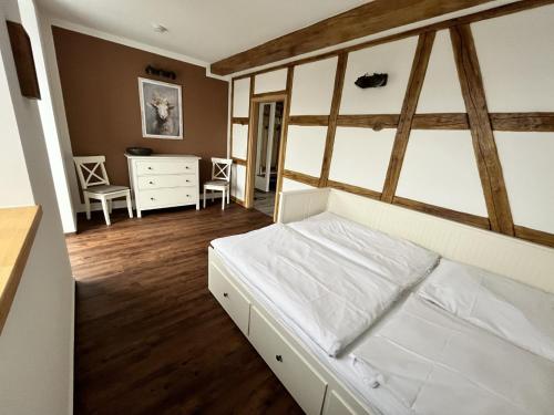 Schlafzimmer mit einem Bett, einem Schreibtisch und Stühlen in der Unterkunft Zur alten Schäferei in Zeulenroda