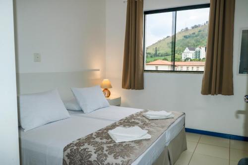 a hotel room with a bed with a window at Metro Hotel in Águas de Lindoia