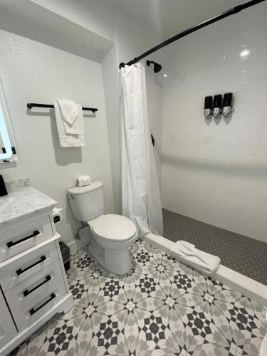 a white bathroom with a toilet and a shower at New Haven Inn in Solvang