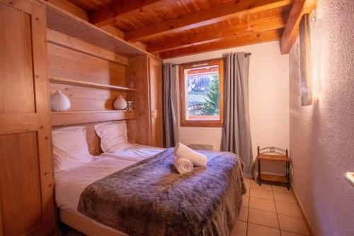 1 dormitorio con 1 cama en una habitación de madera en Tignes les Brévières - Chalet Chardonnay, en Tignes