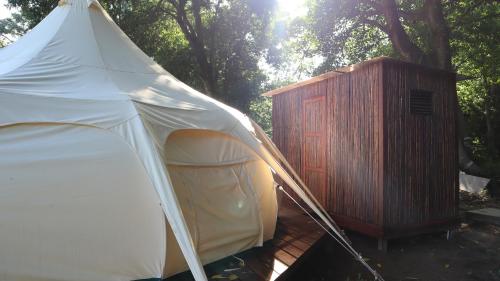 a white tent next to a wooden shed at Cabañas Tequendama - Parque Tayrona in El Zaino