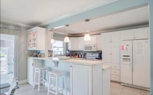 a kitchen with white cabinets and a large island at Dolphin Cove in Cocoa Beach Fl in Cocoa Beach