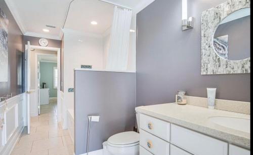 a white bathroom with a toilet and a sink at Dolphin Cove in Cocoa Beach Fl in Cocoa Beach