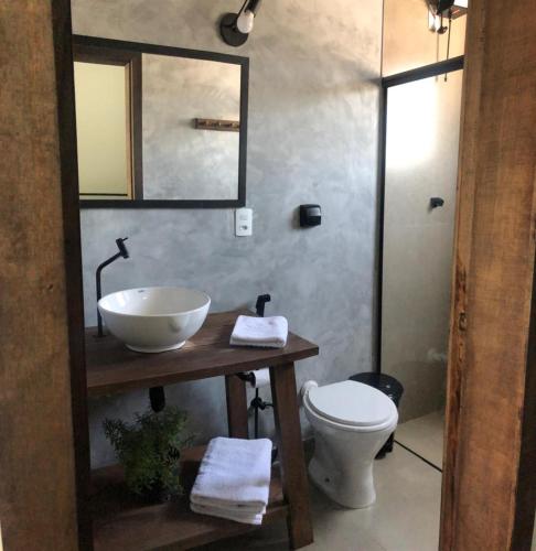 a bathroom with a sink and a toilet and a mirror at The Guest House hostel in Balneário Gaivotas