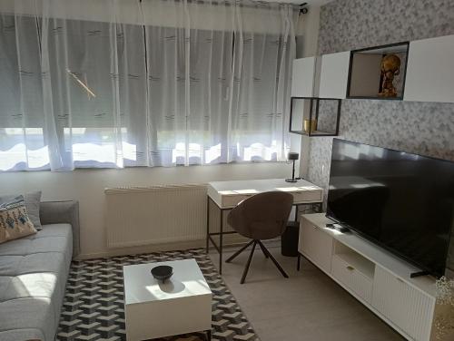 a living room with a couch and a television and a desk at Zagreb Lux apartment in Zagreb