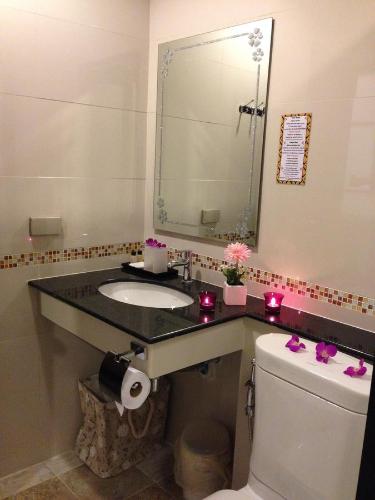 a bathroom with a sink and a toilet and a mirror at Swiss Paradise Boutique Villa in North Pattaya