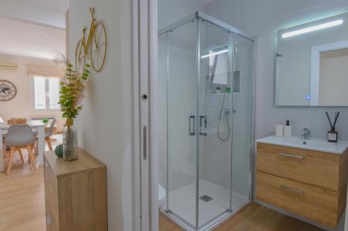 a bathroom with a glass shower and a sink at AROMA APARTAMENTO OLVERA in Olvera