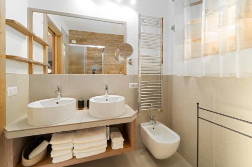 a bathroom with two sinks and a mirror at Dany Lodge Livigno in Livigno