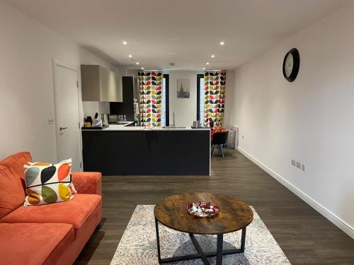 sala de estar con sofá naranja y mesa en Modern en-suite room and self catering in london en Woolwich