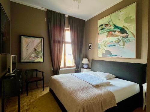 a bedroom with a bed and a large painting on the wall at Apartment PRIVE Zentrum in Leipzig