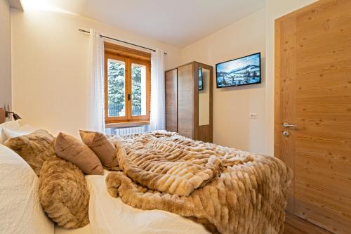 sypialnia z dużym łóżkiem i oknem w obiekcie Dany Lodge Livigno w Livigno