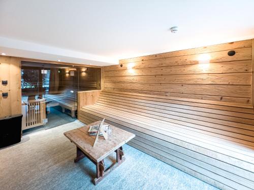 a room with a sauna with a wooden wall at SportLodge GOLF SUITE - Cozy Apartment with Shared Pool, Whirlpool & Sauna, presented by AlpenLuxus in Kleinboden
