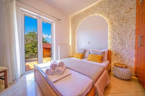 a bedroom with a large bed with towels on it at Villa Lima Pool & Jacuzzi Chania in Vamos