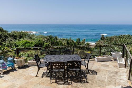 a patio with a table and chairs and the ocean at Seagull Villa in Margate