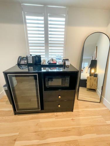 a black dresser with a mirror in a room at New Haven Inn in Solvang