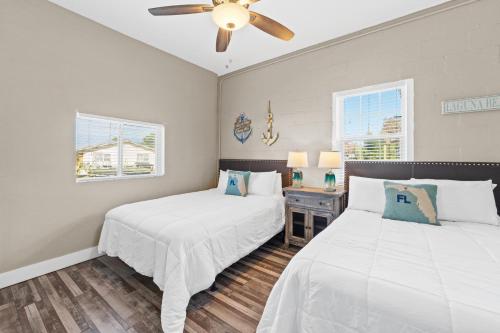 ein Schlafzimmer mit zwei Betten und einem Deckenventilator in der Unterkunft Laguna Matata by Book That Condo in Panama City Beach