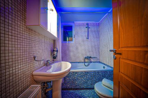 a bathroom with a sink and a tub and a toilet at Villa Lima Pool & Jacuzzi Chania in Vamos