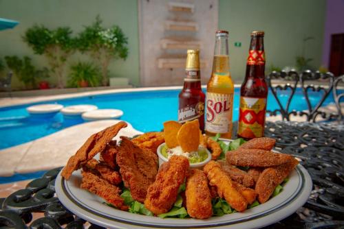 a plate of food on a table next to a pool at Hotel del Gobernador in Mérida