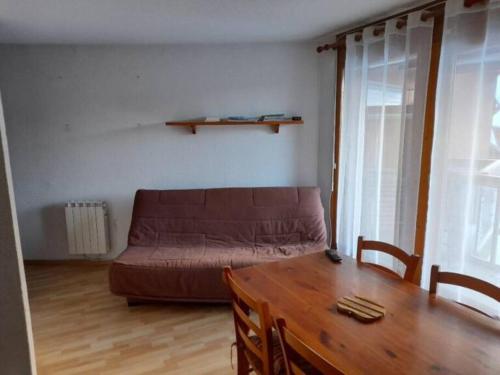 un salon avec un canapé et une table en bois dans l'établissement Les contamines Montjoie 1 CHAMBRE 4 personnes, aux Contamines-Montjoie