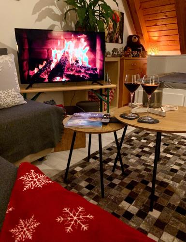 a living room with two tables with wine glasses and a fireplace at FeWo Fuchs Saig in Lenzkirch
