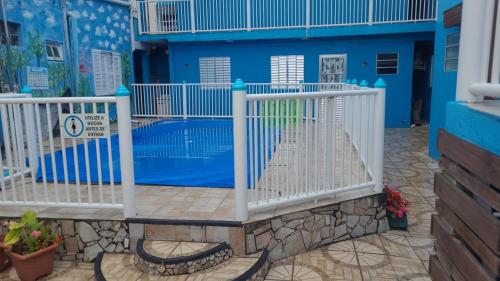 帕蘇迪托雷斯的住宿－Pousada Cantinho Azul，蓝色建筑前的白色围栏