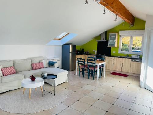 uma sala de estar com um sofá branco e uma cozinha em Gîte Rose des Vignes em Voegtlinshoffen