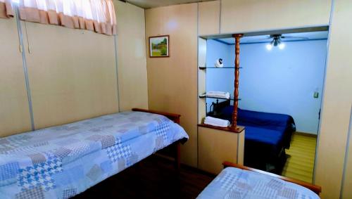 a small bedroom with two beds and a mirror at Alon Ayun Centro Dpto 1 in Mendoza