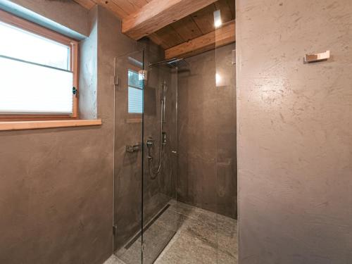 a shower with a glass door in a bathroom at SportLodge GOLF SUITE - Cozy Apartment with Shared Pool, Whirlpool & Sauna, presented by AlpenLuxus in Kleinboden