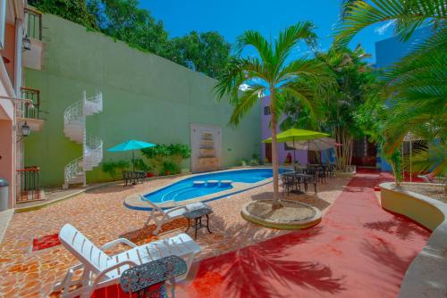 a swimming pool with chairs and umbrellas at Hotel del Gobernador in Mérida