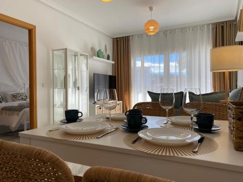 - un salon doté d'une table avec des assiettes et des verres à vin dans l'établissement Casa del Sol, à Calp