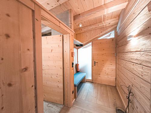 a room with wooden walls and a blue bench at SportLodge GOLF SUITE - Cozy Apartment with Shared Pool, Whirlpool & Sauna, presented by AlpenLuxus in Kleinboden