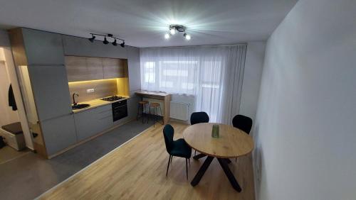 una cucina con un tavolo e sedie in una stanza di Brasov Noua Holiday Apartament a Braşov