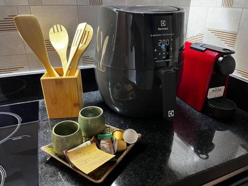 un bancone della cucina con macchinetta del caffè, tazze e utensili di Studio 201 SP Moema Super Equipado a San Paolo