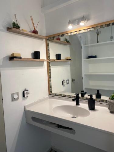 a bathroom with a sink and a mirror at MY Studio vue mer in Le Diamant