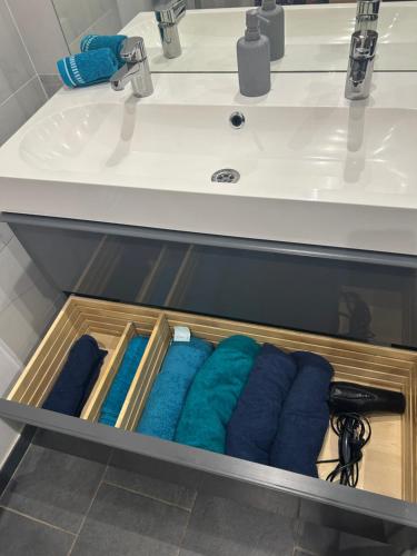uma gaveta debaixo de um lavatório de casa de banho com quatro toalhas em 60m2 au Coeur du Vieux Port em Marselha
