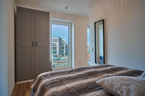 a bedroom with a large bed and a large window at Schön Wohnen auf der Allerinsel in Celle
