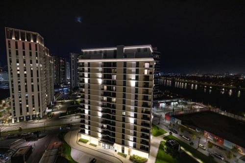 a tall building in a city at night at Belgrade Waterfront Cozy Symphony 2 in Sajmište