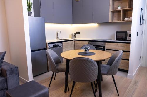 a kitchen with a table and chairs in a room at Belgrade Waterfront Cozy Symphony 2 in Sajmište