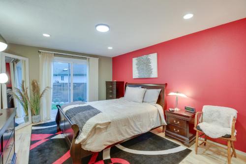 ユージンにあるEugene Vacation Home 8 Mi to University of Oregonの赤い壁のベッドルーム(ベッド1台、椅子付)