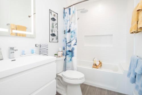 y baño blanco con aseo, lavabo y bañera. en Allure #22 3BR Waterfront, en Red Bay Estate