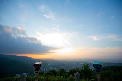 two parking meters on a hill with the sunset in the background at Plumbohms Aussichtsreich Gast- und Logierhaus in Bad Harzburg