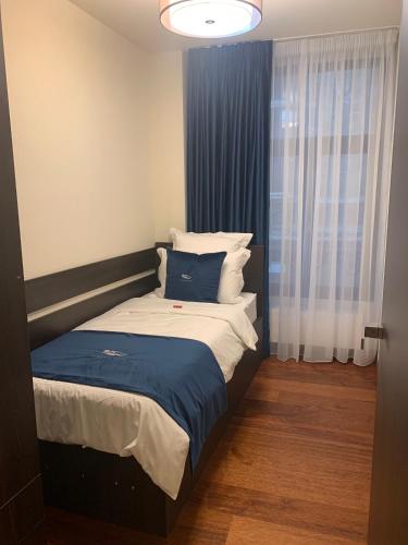 a bedroom with a bed with a blue blanket at Botanique Suites AirBnB, Antwerp in Antwerp
