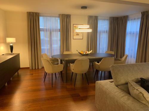 a living room with a dining room table and chairs at Botanique Suites AirBnB, Antwerp in Antwerp