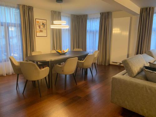 a living room with a table and chairs and a couch at Botanique Suites AirBnB, Antwerp in Antwerp