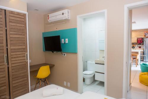 a small bathroom with a toilet and a television at Praia do Cumbuco - Apartamento Completo - VG Sun in Caucaia