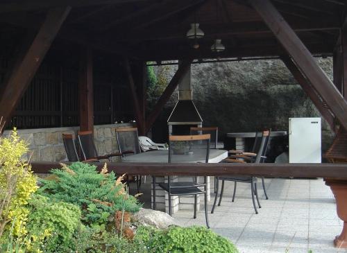 a patio with a table and chairs and a refrigerator at Ubytování Na Výsluní Tanvald in Tanvald